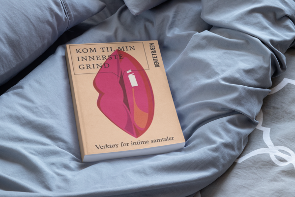 mockup featuring a paperback book placed on a cozy bed 33909